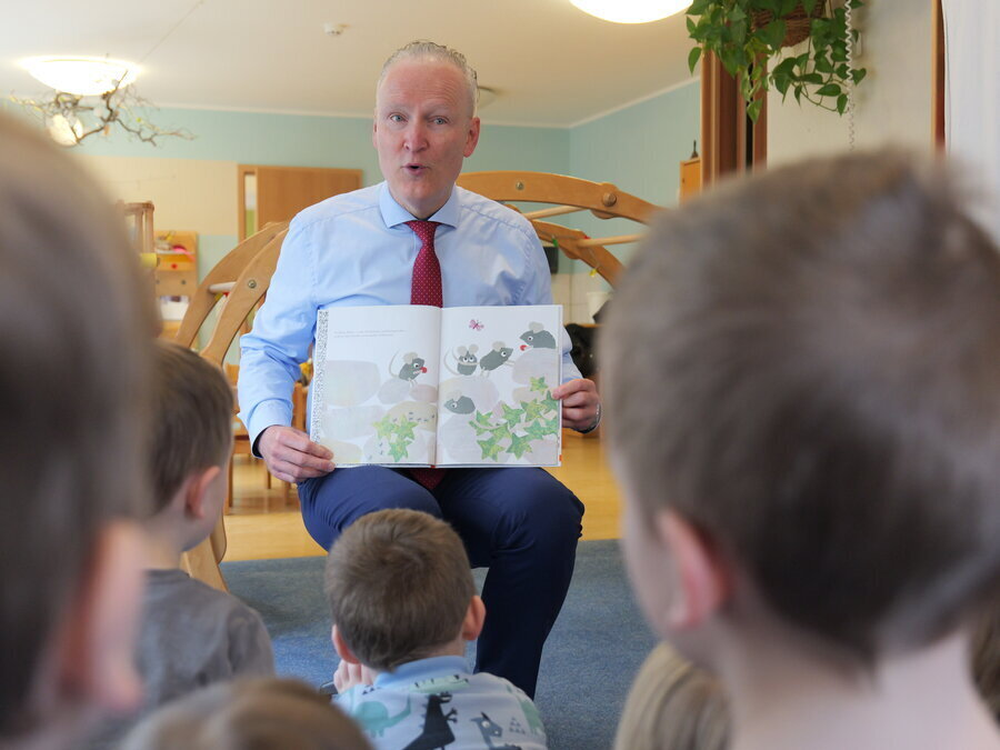 Dr. Axel Steinbach zeigt Bilder in einem Kinderbuch.