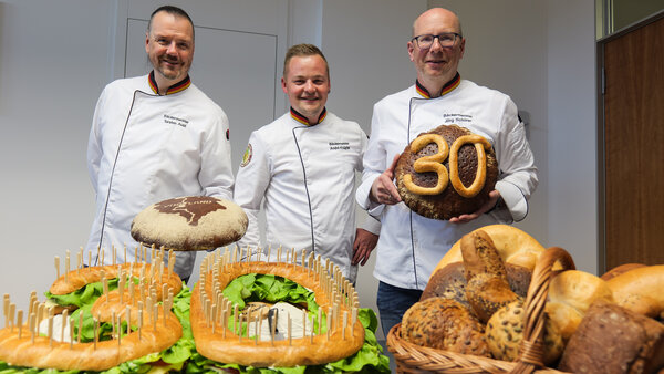 Bild vergr&ouml;&szlig;ern: Die B�ckermeister Torsten Aust, Andr� Kn�pfer und J�rg Sch�rer halten Brote in die Kamera.