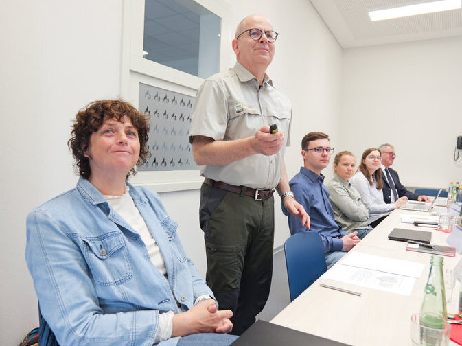 Kay Oertel von der Forstbeh&ouml;rde h&auml;lt eine Pr&auml;sentation. Er steht am Platz, zeigt mit einer Fernbedienung samt Laserpointer auf ein Bild.