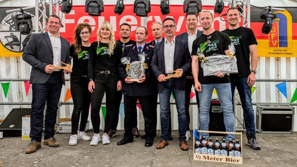 Bild vergr&ouml;&szlig;ern: Vertreter aus der Politik, Mitglieder der Feuerwehr und der ausrichtende Verein posieren f�r ein Gruppenbild.
