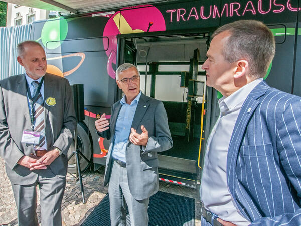Bild vergr&ouml;&szlig;ern: Das BIld zeigt Landrat Rolf Keil im Gespr&auml;ch mit Dr. Hartmut Denkewitz, dem Gesch&auml;ftsf&uuml;hrer des Diakonischen Beratungszentrums Vogtland gGmbH und Marko M&uuml;hlbauer, dem Vorstand der Sparkasse Vogtland. Die drei M&auml;nner stehen vor dem Eingang des Busses.
