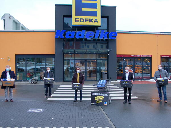 Bild vergr&ouml;&szlig;ern: Das Bild zeigt den Regionalleiter Expansion Jan Hasek, von der EDEKA-Unternehmensgruppe Nordbayern-Sachsen-Th&uuml;ringen zusammen mit dem Marktleiter Ronny Kadelke und Landrat Rolf Keil. In H&auml;nden halten diese die gespendeten FFP2-Masken und die Schnelltests.