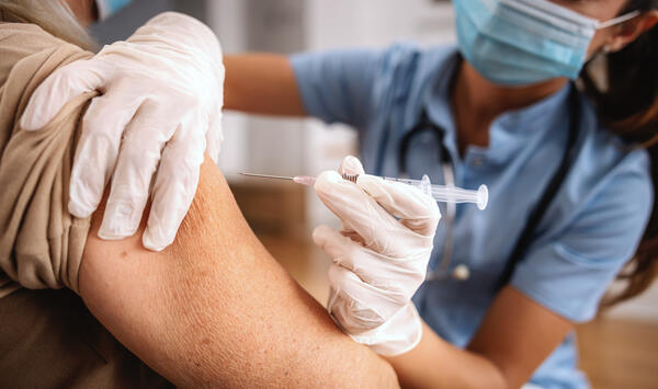 Bild vergr&ouml;&szlig;ern: Das Bild zeigt eine Krankenschwester, die eine Spritze aufgezogen hat und im Begriff ist, mit dieser eine Impfung zu geben.